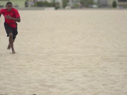 A young man doing speed and agility training with parachutes on the beach.  - Super Slow Motion - filmed at 240 fps Stock Footage