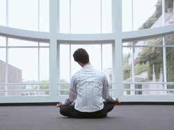  WS Businessman sitting in meditative pose in front of windows / Seattle, Washington, United States Stock Footage