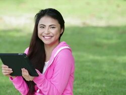 MS Happy young woman playing with a digital tablet in a park. Stock Footage