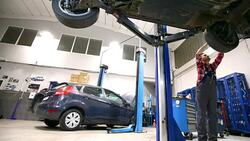Car mechanic working under a vehicle. Stock Footage