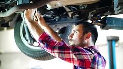 Car mechanic working under a vehicle. Stock Footage