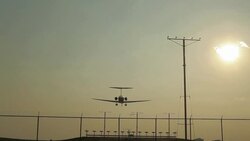 Plane flying in front of Sun landing at Atlanta airport Stock Footage