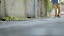 Skater cruises through downtown alleyway on longboard Stock Footage
