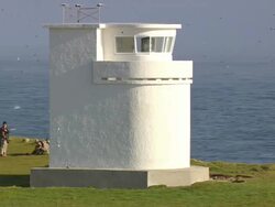 MS AERIAL View of people roaming at Latrabjarg Lighthouse and peninsula / Iceland Stock Footage