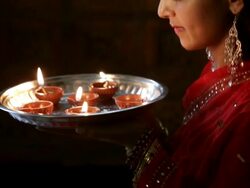 CU TU Side view of young woman bringing tray of oil lamps to her face and smiling / Singapore Stock Footage