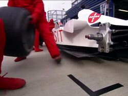 Low angle medium shot rear tire of Formula One race car being changed by pit crew Stock Footage