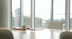 Coffee cup, digital tablet, notepad on desk in empty office Stock Footage
