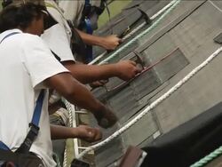 MS Shot of workers hammering on roof of red building / Chelsea, Michigan, United States Stock Footage