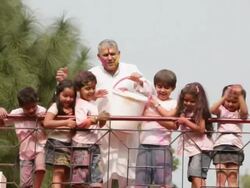 Senior man playing holi festival with his grandchildren at roof top  Stock Footage