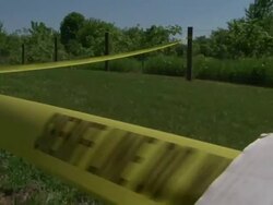 Close Up hand-held tracking-right - A sheriff stretches crime scene tape across a cemetery lawn. / USA Stock Footage