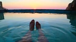 Guy from personal perspective swimming in a natural pool in the Mediterranean Sea Costa Brava recording his feet with the sunrise on the background in a stunning outdoor with great colors. Stock Footage