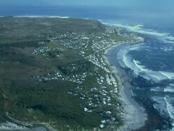 WS ZI AERIAL View of Slangkop lighthouse and suburb of Kommetjie / Cape Town, Western Cape, South Africa Stock Footage