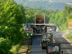 WS HA Shot of two steam roller with dumper and workers working on re surfacing of road / Saarburg, Rhineland-Palatinate, Germany Stock Footage