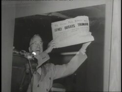 A photograph captures President Harry S. Truman smiling and holding up a newspaper with the headline, Dewey Defeats Truman. News Clip