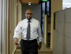 African American businessman walking down office corridor stops for flying paperwork Stock Footage