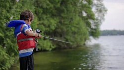 Young boy fishing on lake Stock Footage