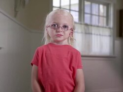 Litttle blond girl with Cochlear Implant standing in a hall way Stock Footage