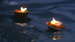 Lighted candles float on water at night. Stock Footage