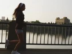 MS Side POV SLO MO Shot of beautiful female jogger on city water front park at sunset / Portland, Oregon, United States  Stock Footage