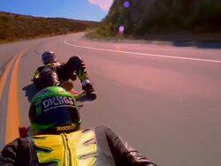 CANTED close up tracking shot two street lugers coming together on mountain road Stock Footage