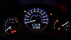 Car speedometer and fuel gauge on dashboard at night Stock Footage
