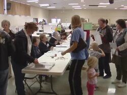 MS, People picking up voting ballots from tables at polling place, St, Marys, Ohio, USA Stock Footage