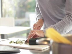 Female in kitchen preparing food and looking at ipad Stock Footage