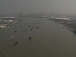 Wide angle aerial view of multiple barges sailing along river through Shanghai, China Stock Footage