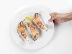 CU Woman hand entering setting down round white plate with crab claws / Omaha, Nebraska, United States Stock Footage