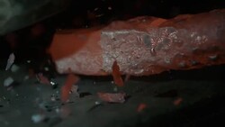 Red hot piece of metal being hammered in slow motion Stock Footage