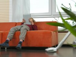 HD DOLLY: Cheerful Teenage Girl Vacuuming Floor Stock Footage