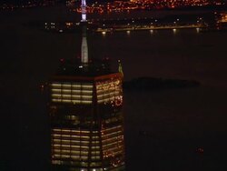 Aerial -At night, passing by the upper floors of the Freedom Tower to hold on the Statue of Liberty in the distance. Stock Footage