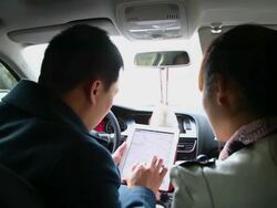 MS Shot of couple in car reading map on tablet computer and pointing / Xian, China Stock Footage