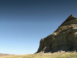 A cliff in the prairies with a beuatiful blue sky Stock Footage