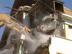 MS Demolition of apartment block and man watering / Saarburg, Rhineland-Palatinate, Germany Stock Footage