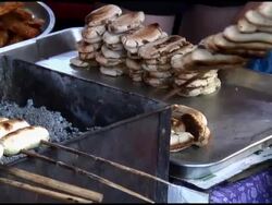 Food Preparation: Taking Grilled Bananas / Plntans off Skewers Stock Footage