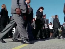 Low angle medium shot crowd of businesspeople walking back and forth / stopping + sneezing Stock Footage