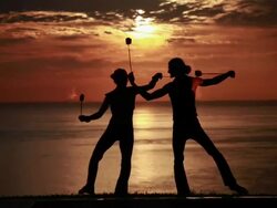 MS Sihouetted couple perform poi dance together in front of fiery sunrise and ocean / Montezuma, Costa Rica Stock Footage