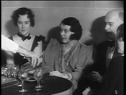 B/W 1933 hand of male bartender pouring drinks for group sitting at table / end of Prohibition Stock Footage