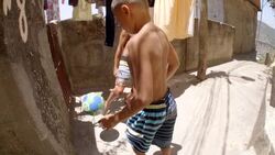 Young Brazilian boys pass soccer ball down narrow alleyways through Rio slums Stock Footage