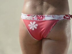 ECU CU of female beach volleyball player's hand on her buttocks signaling her partner. Stock Footage