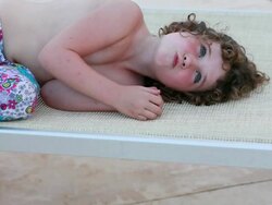 MS Little girl lying on lawnchair making faces into camera / Montezuma, Nicoya Peninsula, Costa Rica  Stock Footage