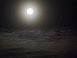 WS T/L View of moon passing from frame with moving clouds / Arviat, Nunavut, Canada Stock Footage