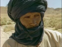 CU Arab man's wrinkled face, wearing head scarf around head and covering face, Algeria, Africa Stock Footage