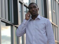 Business executive on the phone in front of office Stock Footage