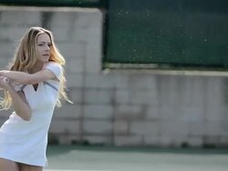 CU of a female tennis player as she hits the tennis ball backhand and water sprays. Stock Footage