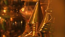 Brass lamps and urns hang in a vendor's booth at an Indian market. Stock Footage