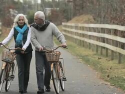 Mature couple walking with bicycles Stock Footage