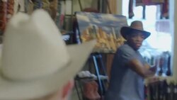 Young man in cowboy hat has fake shootout with friend in Western store and blows on his finger like a smoking gun Stock Footage