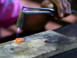 Goldsmith Jeweler use gasoline burner melting and decorating ring Stock Footage